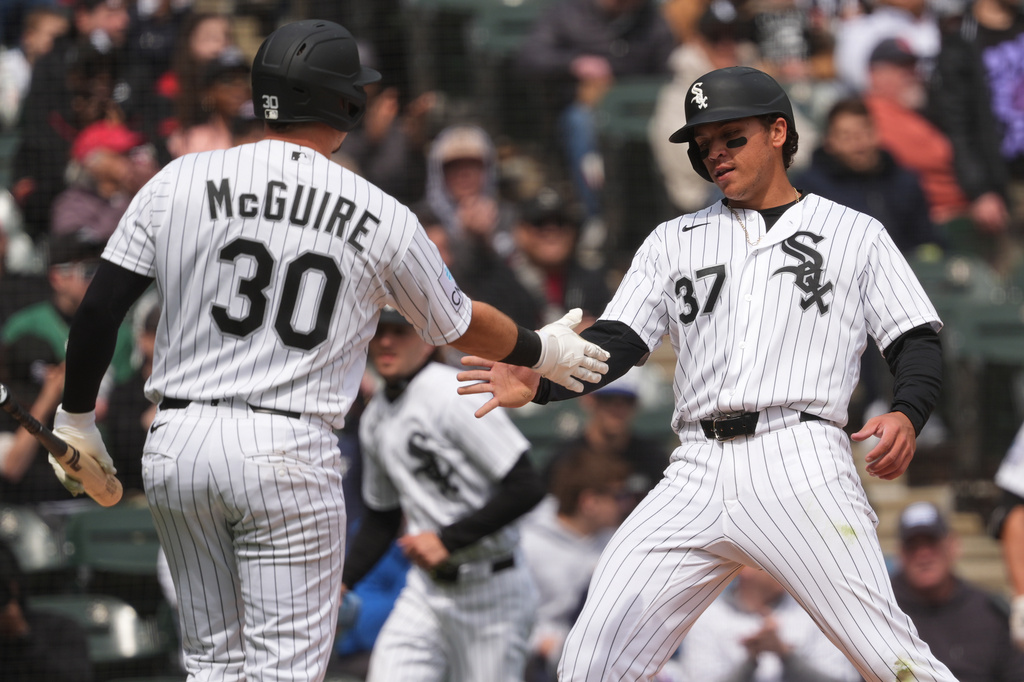Chicago White Sox's Dustin Harris, right, celebrates with Reese McGuire after scoring on a one-run single by Luisangel Acuna during the second inning of a baseball game against the Baltimore Orioles in Chicago, Wednesday, April 8, 2026. (AP Photo/Nam Y. Huh)