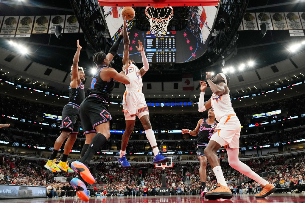 Phoenix Suns guard Jalen Green (4) drives to the basket past Chicago Bulls forward Guerschon Yabusele (28) and guard Collin Sexton, left, during the first half of an NBA basketball game, in Chicago, Sunday, April 5, 2026. (AP Photo/Nam Y. Huh)