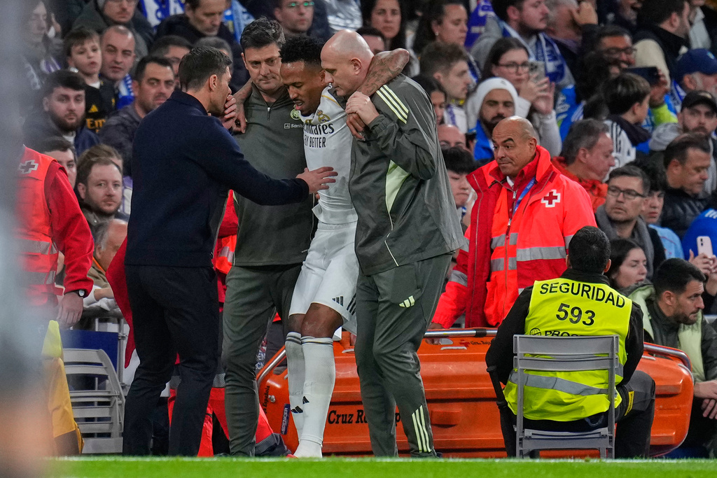 Real Madrid's head coach Xabi Alonso checks on Eder Militao who is assisted from the pitch after getting an injury during the Spanish La Liga soccer match between Real Madrid and Celta Vigo in Madrid, Spain, Sunday, Dec. 7, 2025. (AP Photo/Manu Fernandez)
