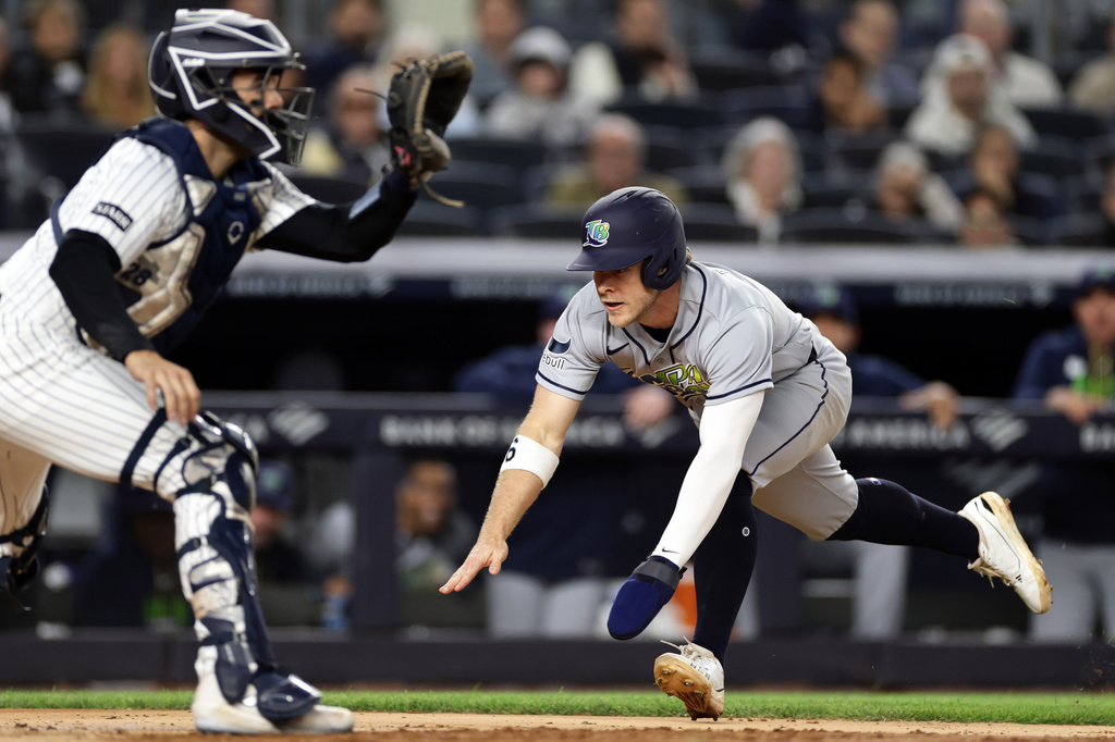 Tampa Bay Rays' Taylor Walls scores a run past New York Yankees catcher Austin Wells in the seventh inning during the second baseball game of a doubleheader Tuesday, Sept. 22, 2026, in New York. (AP Photo/Adam Hunger)