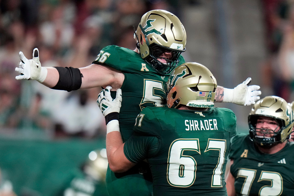 South Florida Bulls offensive lineman Cole Skinner (56) celebrates his touchdown against Florida Atlantic with offensive lineman Thomas Shrader (67) during the first half of an NCAA college football game Saturday, Oct. 18, 2025, in Tampa, Fla. (AP Photo/Chris O'Meara)
