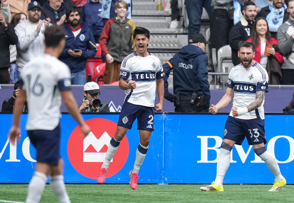 Vancouver Whitecaps' Mathias Laborda (2) and Tristan Blackmon (33) celebrate after Laborda's goal during the first half of an MLS soccer match against New York City FC in Vancouver, British Columbia, Saturday, April 11, 2026. (Darryl Dyck/The Canadian Press via AP)