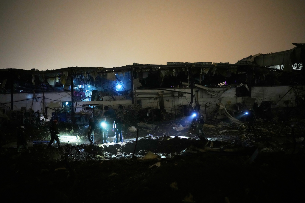 Israeli security forces and rescue teams inspect a site struck by an Iranian missile in Petah Tikva, Israel,Thursday, April 2, 2026. (AP Photo/Ohad Zwigenberg)