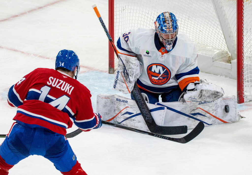 New York Islanders goaltender Ilya Sorokin (30) makes a save against Montreal Canadiens' Nick Suzuki (14) during second-period NHL hockey game action in Montreal, Thursday, Feb. 26, 2026. (Christinne Muschi/The Canadian Press via AP)