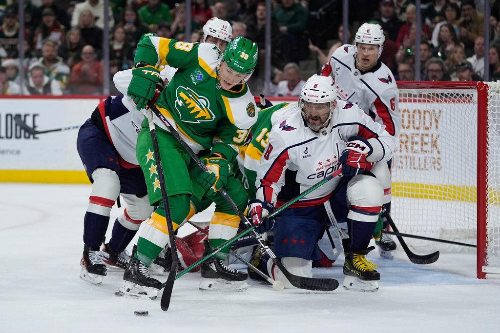 Minnesota Wild center Ben Jones (39) and Washington Capitals left wing Alex Ovechkin (8) battle for the puck during the first period of an NHL hockey game, Tuesday, Dec. 16, 2025, in St. Paul, Minn. (AP Photo/Abbie Parr)