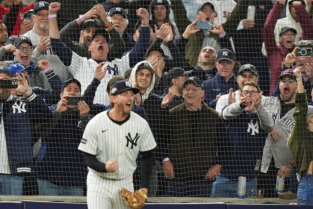 New York Yankees fans react as New York Yankees third baseman Ryan McMahon makes a catch for the final out against the Boston Red Sox to win Game 3 of an American League wild-card baseball playoff series, Thursday, Oct. 2, 2025, in New York. (AP Photo/Frank Franklin II)
