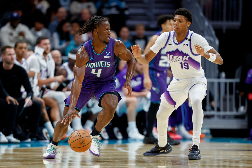 Charlotte Hornets guard Sion James (4) moves the ball against Utah Jazz guard Ace Bailey during the first half of an NBA basketball game in Charlotte, N.C., Sunday, Nov. 2, 2025. (AP Photo/Nell Redmond)