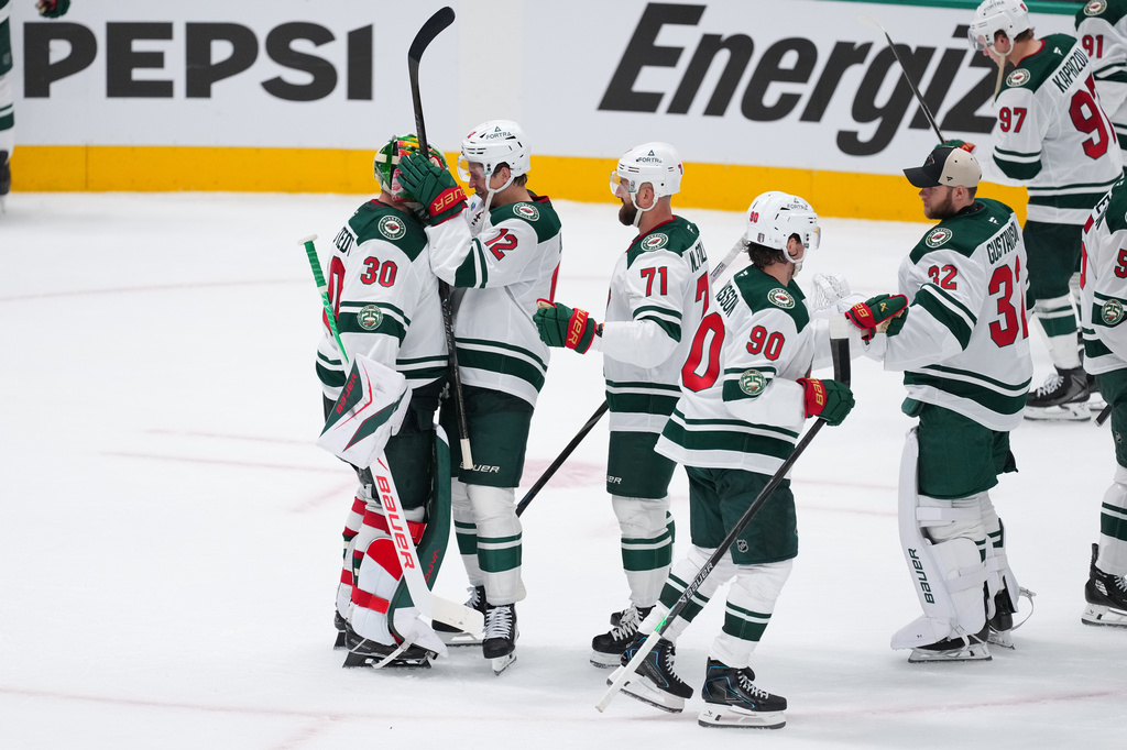 Minnesota Wild goaltender Jesper Wallstedt (30) reacts with left wing Matt Boldy (12) after defeating the Dallas Stars 6-1 in Game 1 of a first-round NHL Stanley Cup playoffs hockey series, Saturday, April 18, 2026, in Dallas, Texas. (AP Photo/Julio Cortez)