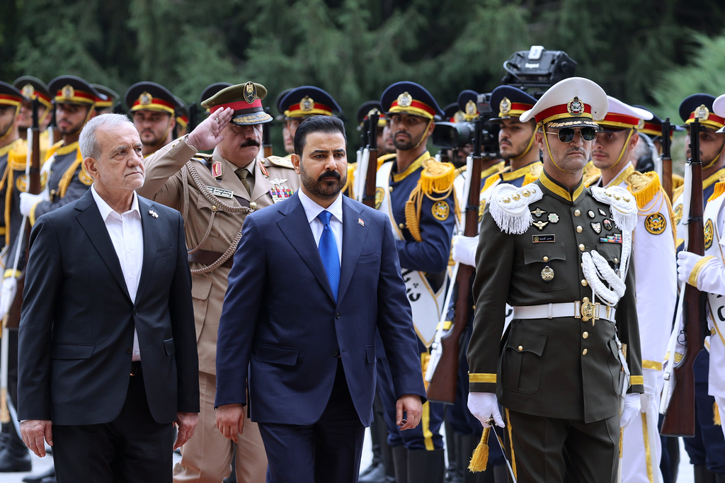In this photo released by the Iranian Presidency Office, Iraq's Prime Minister Ali al-Zaidi, center, reviews an honor guard as he is welcomed by the Iranian President Masoud Pezeshkian, left, during his official welcoming ceremony in Tehran, Iran, Thursday, July 22, 2026. (Iranian Presidency Office via AP)
