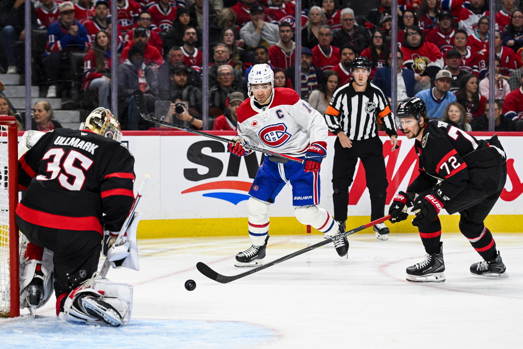 Montreal Canadiens' Nick Suzuki (14) looks for a rebound off of Ottawa Senators' goaltender Linus Ullmark (35) during the first period of an NHL hockey game in Ottawa, Wednesday, March 11, 2026. (Spencer Colby/The Canadian Press via AP)