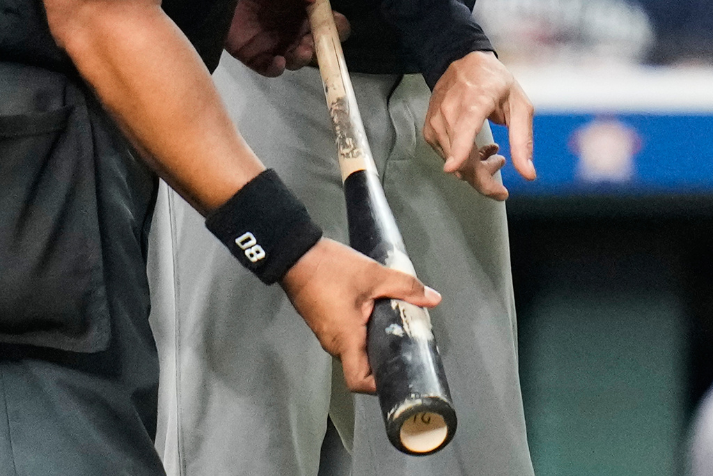 New York Yankees manager Aaron Boone, right, points at Houston Astros' Taylor Trammell's bat held by home plate umpire Adrian Johnson during the ninth inning of a baseball game Thursday, Sept. 4, 2025, in Houston. (AP Photo/Karen Warren)
