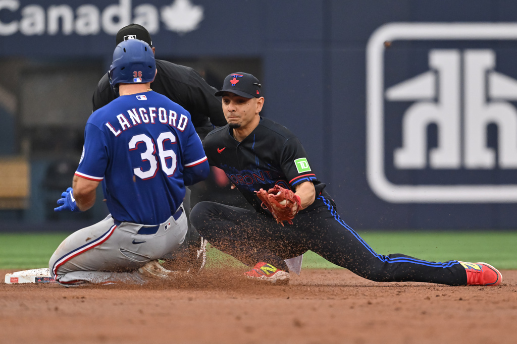 Texas Rangers Wyatt Langford (36) is tagged out at second base by Toronto Blue Jays infielder Andres Gimenez (0) during the second inning of a baseball game in Toronto, Friday June 26, 2026. (Jon Blacker/The Canadian Press via AP)