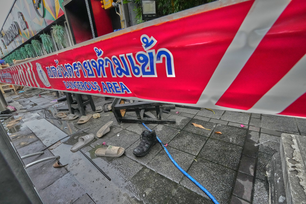 Shoes are seen scattered in front of a pub in Bangkok, Thailand, Monday, July 13, 2026, after a fire. (AP Photo/Sakchai Lalit)