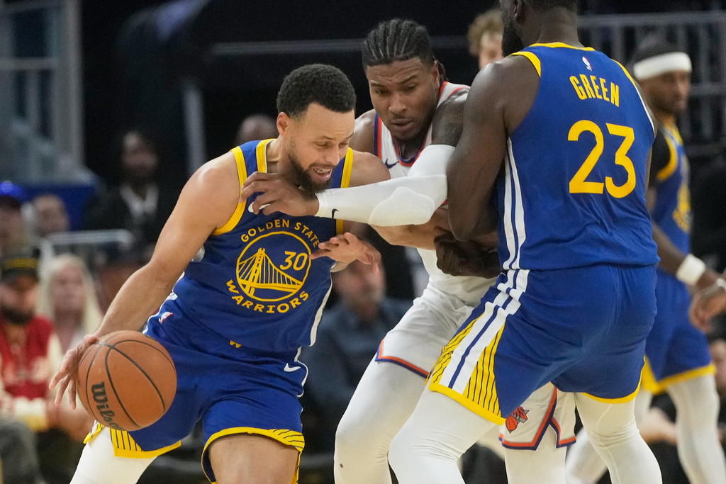 Golden State Warriors guard Stephen Curry (30) dribbles the ball as forward Draymond Green (23) screens New York Knicks guard Miles McBride, middle, during the first half of an NBA basketball game in San Francisco, Thursday, Jan. 15, 2026. (AP Photo/Jeff Chiu)