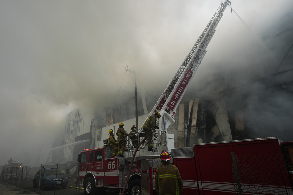 Firefighters fight a warehouse fire in the Boyle Heights neighborhood of Los Angeles, Sunday, June 21, 2026. (AP Photo/Jae C. Hong)