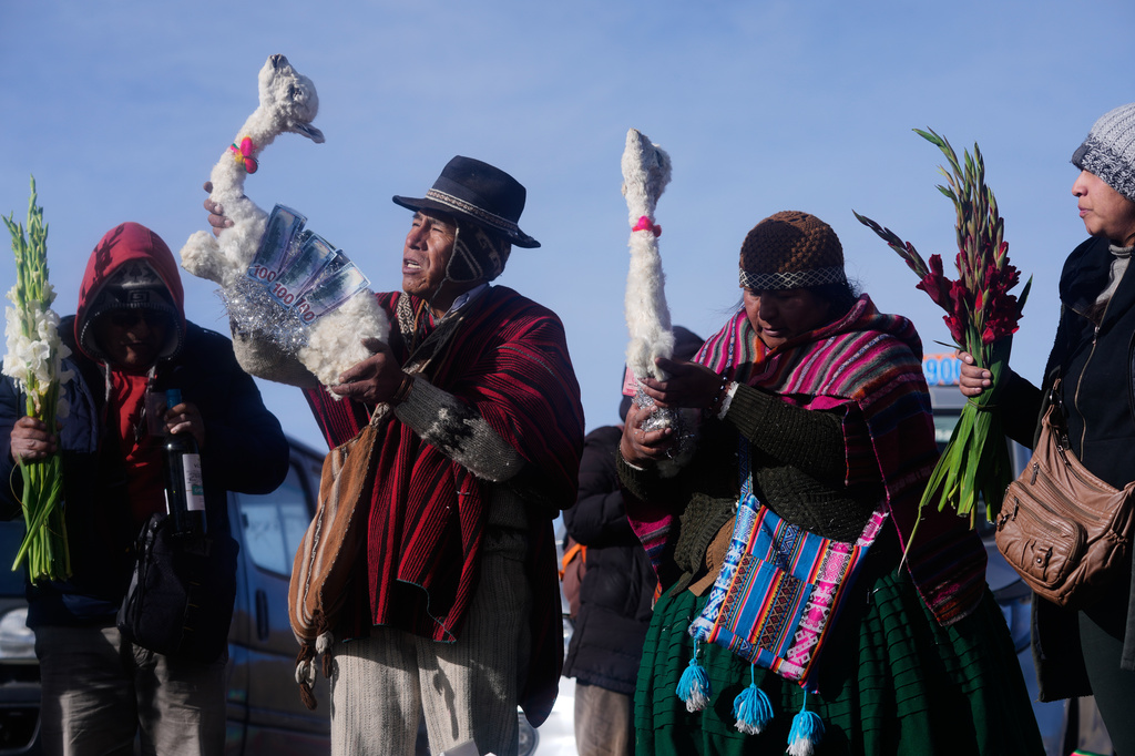 Spiritual leaders hold llama carcasses to be burned as offerings to Pachamama, or Mother Earth, during an ancient ritual to pray for a good harvest on La Cumbre, a sacred mountain on the outskirts of La Paz, Bolivia, Saturday, Aug. 1, 2026. (AP Photo/Juan Karita)
