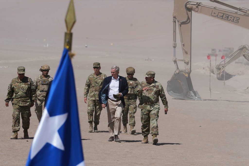 Chilean President Jose Antonio Kast walks past diggers along the northern border at the Chacalluta border crossing in Arica, Chile, Monday, March 16, 2026, as part of measures to deter irregular migration. (AP Photo/Esteban Felix)