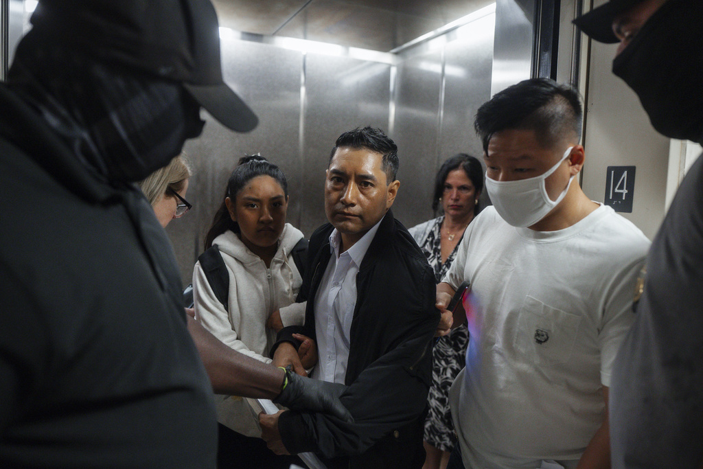 Immigration and Customs Enforcement agents pull a man out of an elevator as he and his daughter attempt to leave following a hearing in immigration court, Friday, Sept. 5, 2025, in New York. (AP Photo/Olga Fedorova)