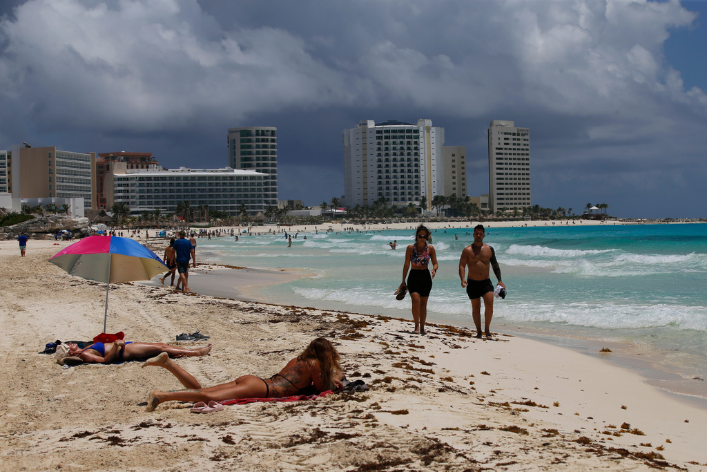 FILE - Tourists sunbathe on the beach before the arrival of Hurricane Grace, in Cancun, Quintana Roo State, Mexico, Aug. 18, 2021. (AP Photo/Marco Ugarte, File)