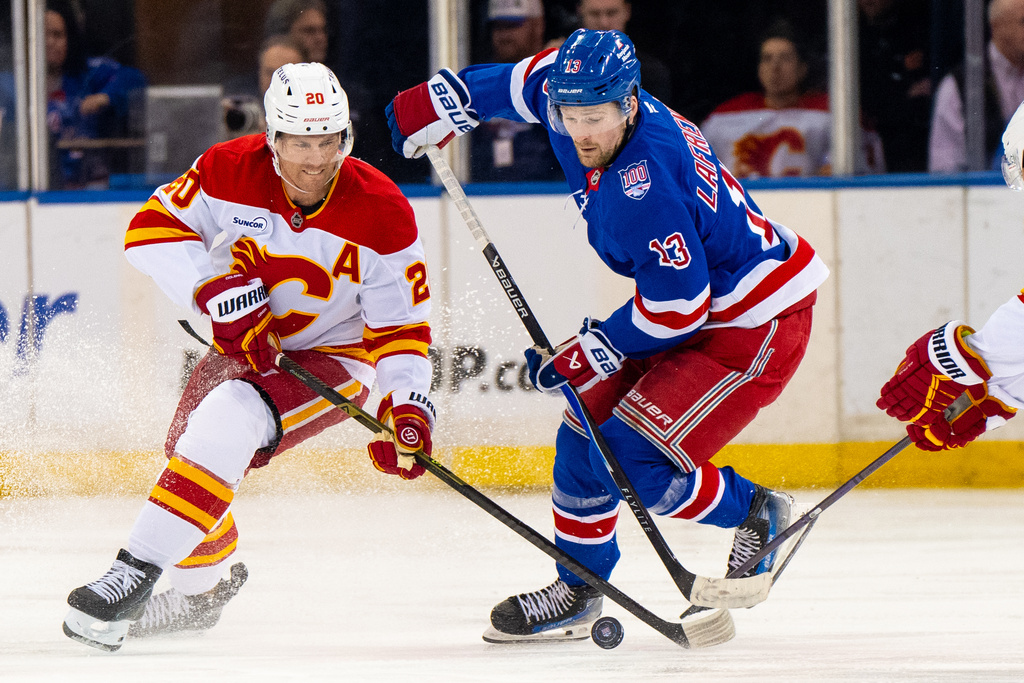 New York Rangers left wing Alexis Lafrenière (13) and Calgary Flames left wing Blake Coleman (20) battle for the puck during the second period of an NHL hockey game, Tuesday, March 10, 2026, in New York. (AP Photo/Angelina Katsanis)