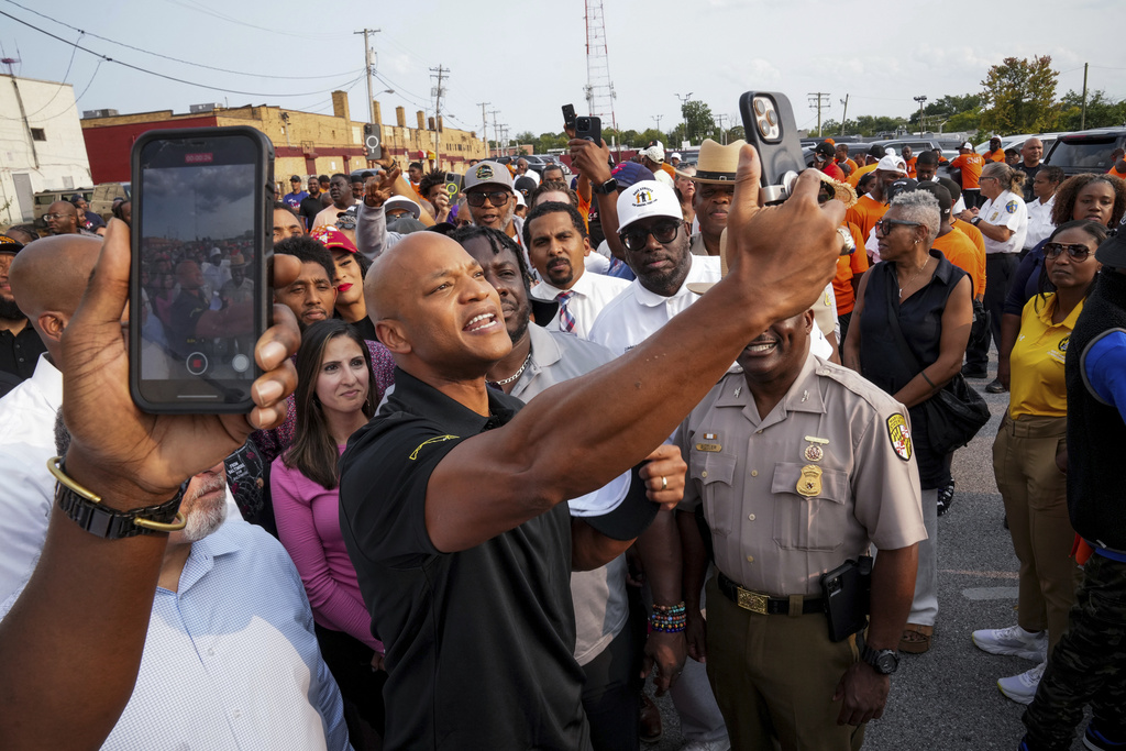 CORRECTS TO POOL PHOTO - Maryland Gov. Wes Moore takes selfies with attendees ahead of a Community Walk in northwest Baltimore, Md., on Friday, Sept. 5, 2025. (Ulysses Muñoz/The Baltimore Banner via AP, Pool)
