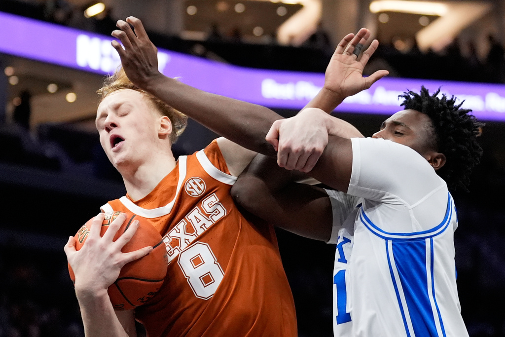 Texas center Matas Vokietaitis drives to the basket past Duke center Patrick Ngongba during the first half of an NCAA college basketball game, Tuesday, Nov. 4, 2025, in Charlotte, N.C. (AP Photo/Chris Carlson)