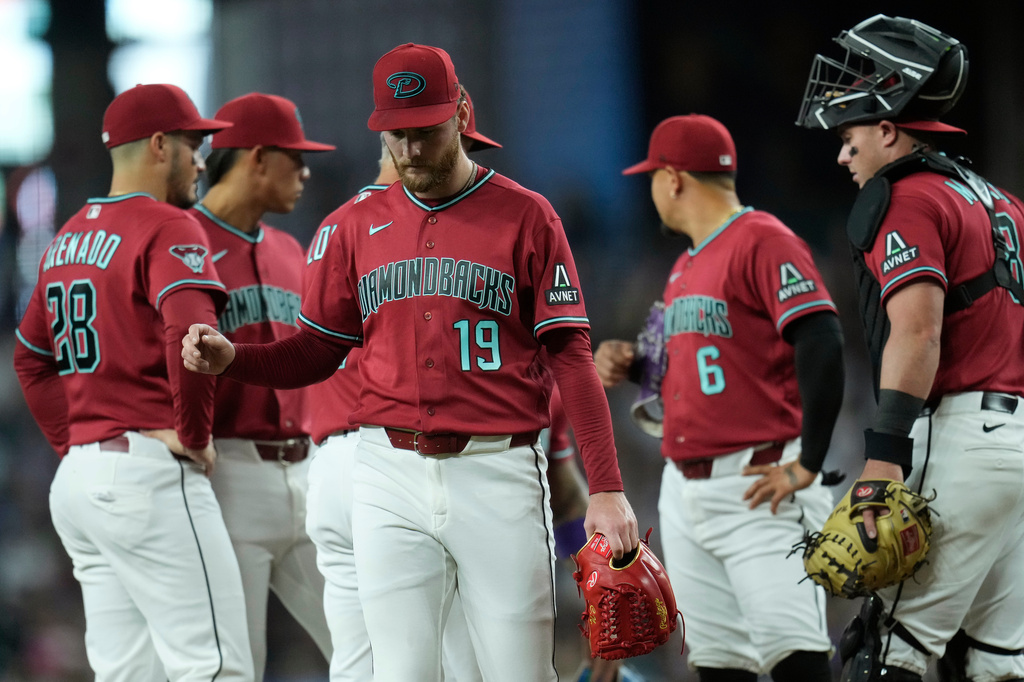 Arizona Diamondbacks starting pitcher Ryne Nelson (19) walks off the field as Diamondbacks third baseman Nolan Arenado (28), shortstop Jose Fernandez (11), second baseman Ildemaro Vargas (6) and catcher James McCann, right, wait for a new pitcher during the first inning of a baseball game against the Toronto Blue Jays, Sunday, April 19, 2026, in Phoenix. (AP Photo/Ross D. Franklin)