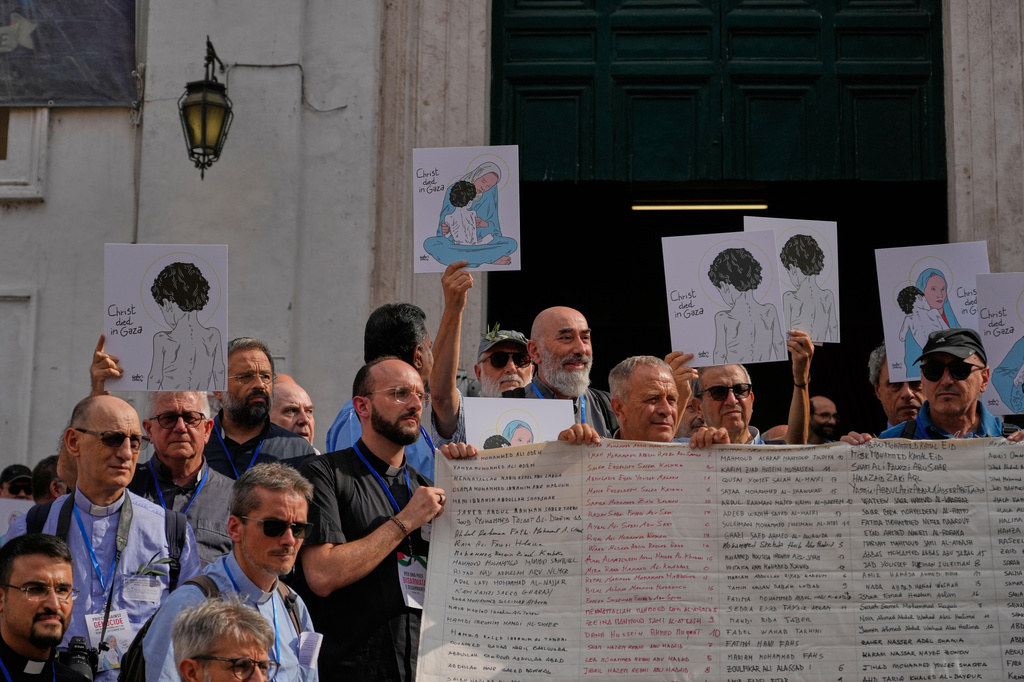 Priests from various countries, members of the "Priests Against Genocide" network, carry a shroud bearing the names of 300 Palestinian and Lebanese children whom organizers say were killed by the Israeli military after ceasefires were declared, during a demonstration near St. Peter's Square at the Vatican, Tuesday, Sept. 22, 2026. (AP Photo/Gregorio Borgia)