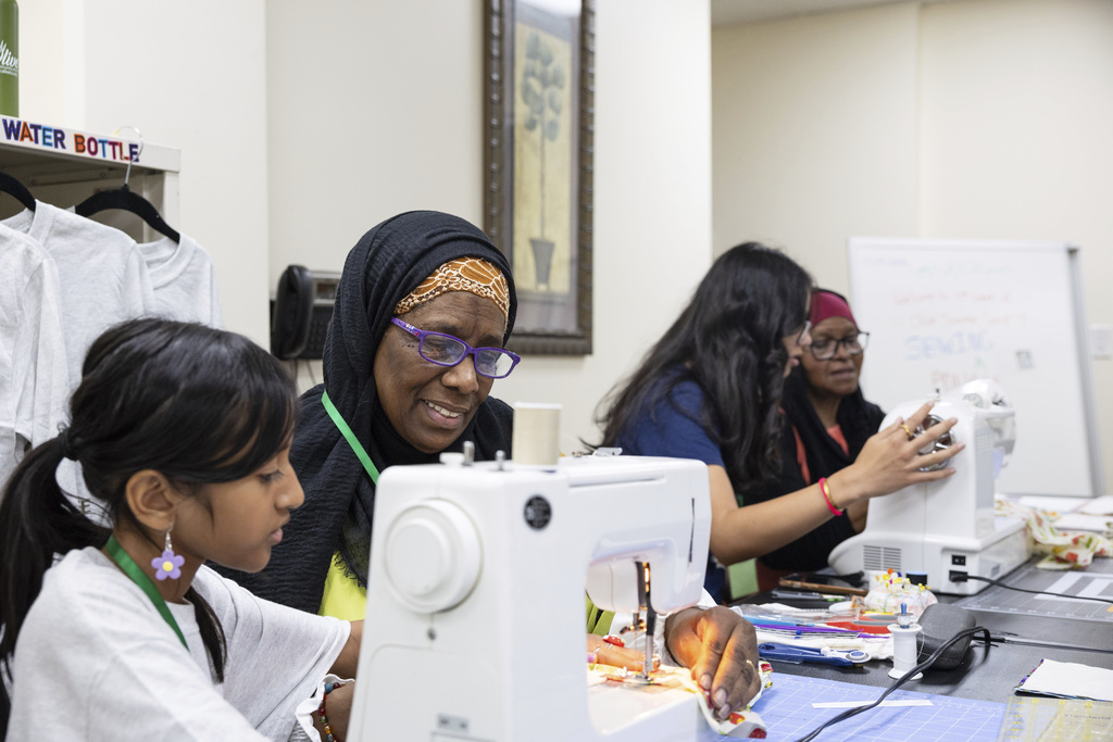 Priyanka Chaudhary, 10, learns how to use a sewing machine with teacher Haqiqah Abdul Rahim at Olive Community Services, Tuesday, July 29, 2025, in Fullerton, Calif. The class was part of the organization's Intergenerational Summer Camp. (AP Photo/Zoë Meyers)