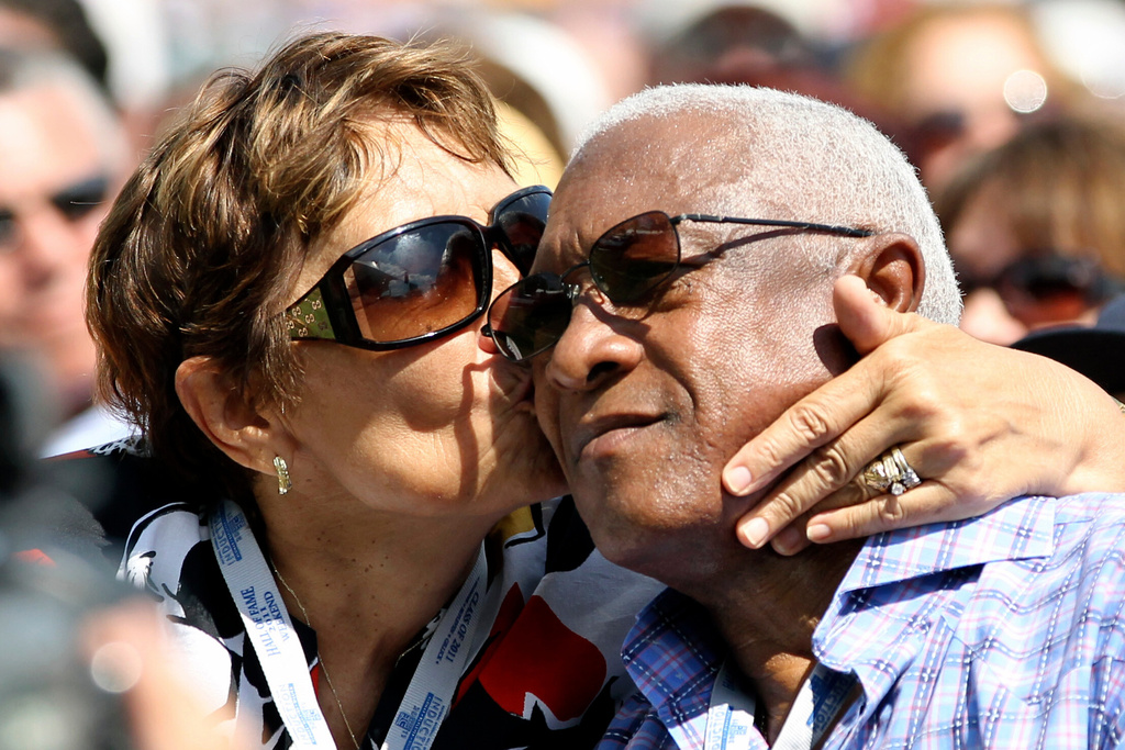FILE - Maria Alomar, left, kisses her husband Sandy Alomar Sr., as their son Roberto Alomar gives his Baseball Hall of Fame induction speech during a ceremony at the Clark Sports Center in Cooperstown, N.Y., July 24, 2011. (AP Photo/Mike Groll, File)