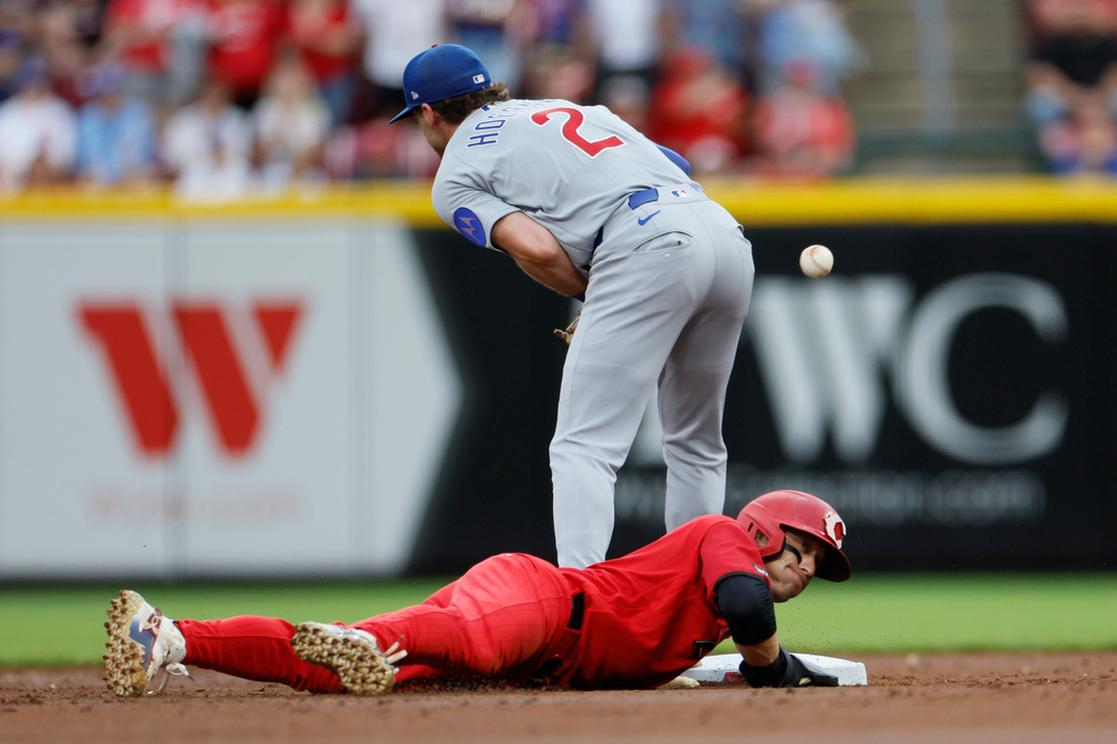 Cincinnati Reds' TJ Friedl, bottom, dives safely back to second base as Chicago Cubs second baseman Nico Hoerner (2) bobbles the ball during the third inning of a baseball game, Saturday, July 11, 2026, in Cincinnati. (AP Photo/Jay LaPrete)
