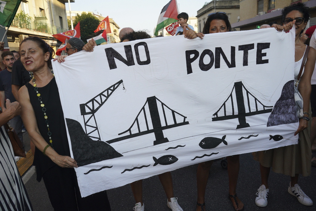 People hold a banner during a demonstration against the bridge in Messina, Italy on Saturday, Aug. 9, 2025 (Francesco Saya/LaPresse via AP)