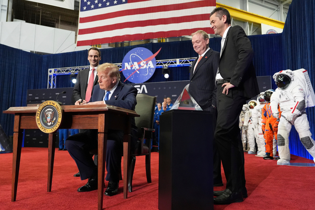 President Donald Trump signs an executive order creating the U.S. Space Academy as Michael Kratsios, White House Science and Technology advisor, from left, Kevin Hassett, director of the National Economic Council, and NASA Administrator Jared Isaacman look on during an event to present the Congressional Space Medal of Honor to Artemis II crew members, Friday, Aug. 28, 2026, at Johnson Space Center in Houston. (AP Photo/Mark Schiefelbein)