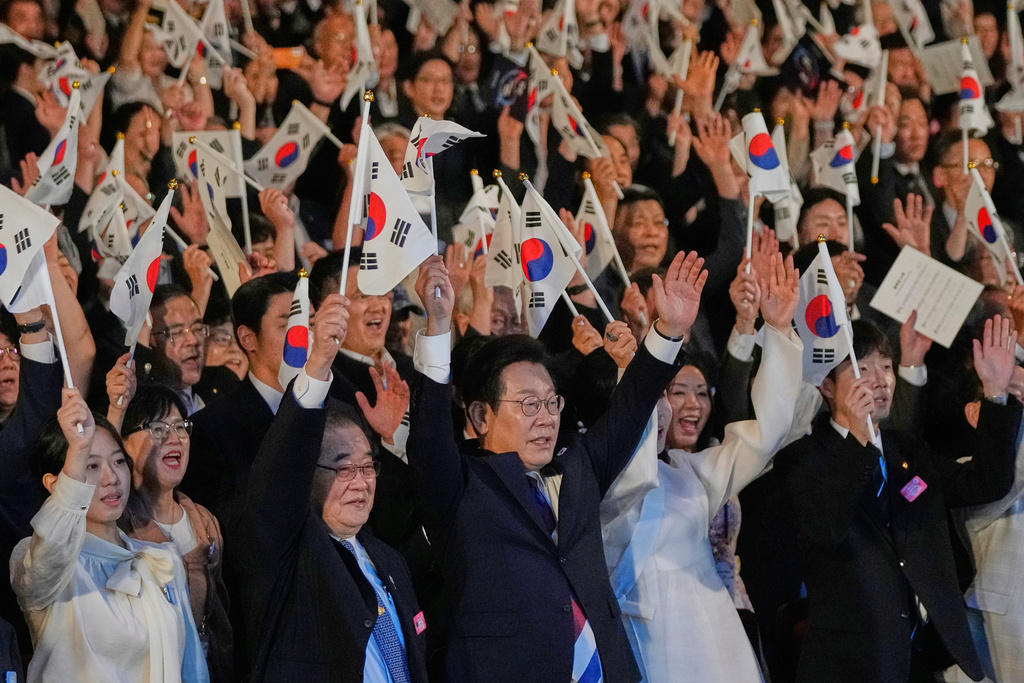 South Korean President Lee Jae Myung, center, waves the national flag and cheers during the 80th anniversary of Korea's liberation from Japanese colonial rule in Seoul, South Korea, Friday, Aug. 15, 2025. (AP Photo/Ahn Young-joon, Pool)