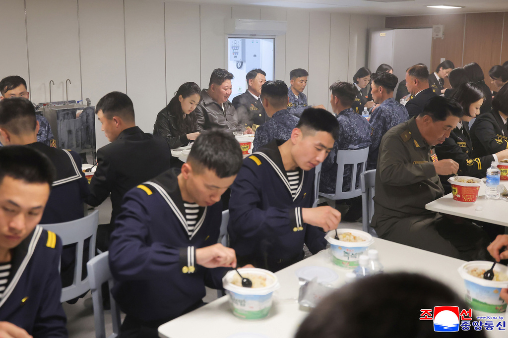 In this photo provided on May 8, 2026, by the North Korean government, its leader Kim Jong Un, rear center, and his daughter have meal with sailors on the destroyer Choe Hyon off North Korea's west coast, Thursday, May 7, 2026. Independent journalists were not given access to cover the event depicted in this image distributed by the North Korean government. The content of this image is as provided and cannot be independently verified. Korean language watermark on image as provided by source reads: "KCNA" which is the abbreviation for Korean Central News Agency. (Korean Central News Agency/Korea News Service via AP)