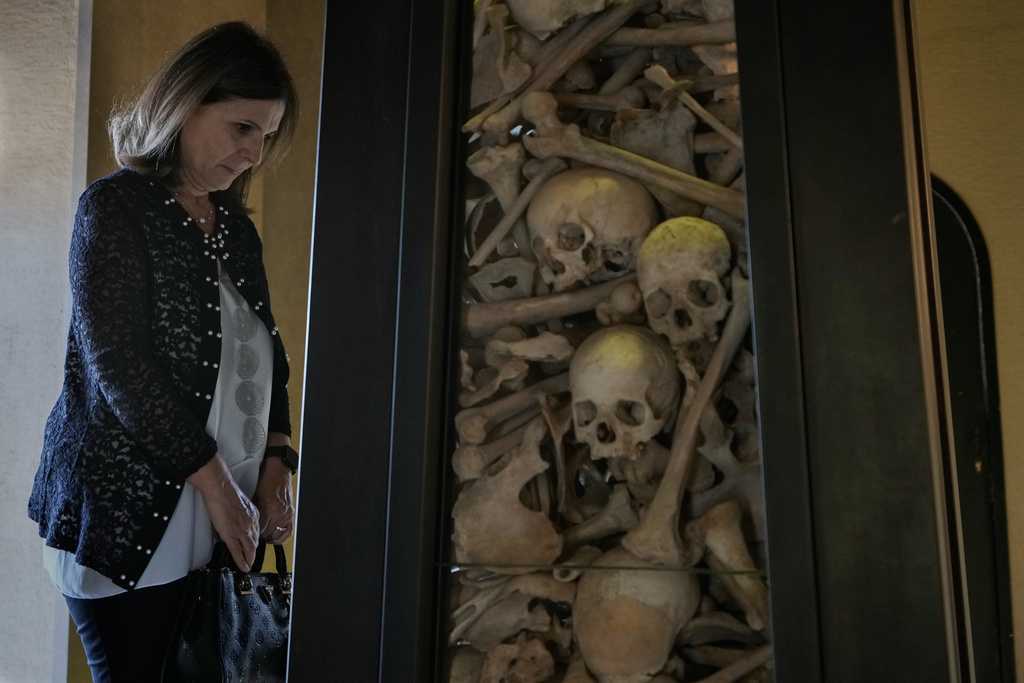 A Lebanese woman of Armenian descent prays by human remains of people killed by Ottoman Turks around the time of World War I in 1915, inside the Armenian Patriarchate in Antelias, north of Beirut, Lebanon, Sunday, Nov. 23, 2025. (AP Photo/Bilal Hussein)