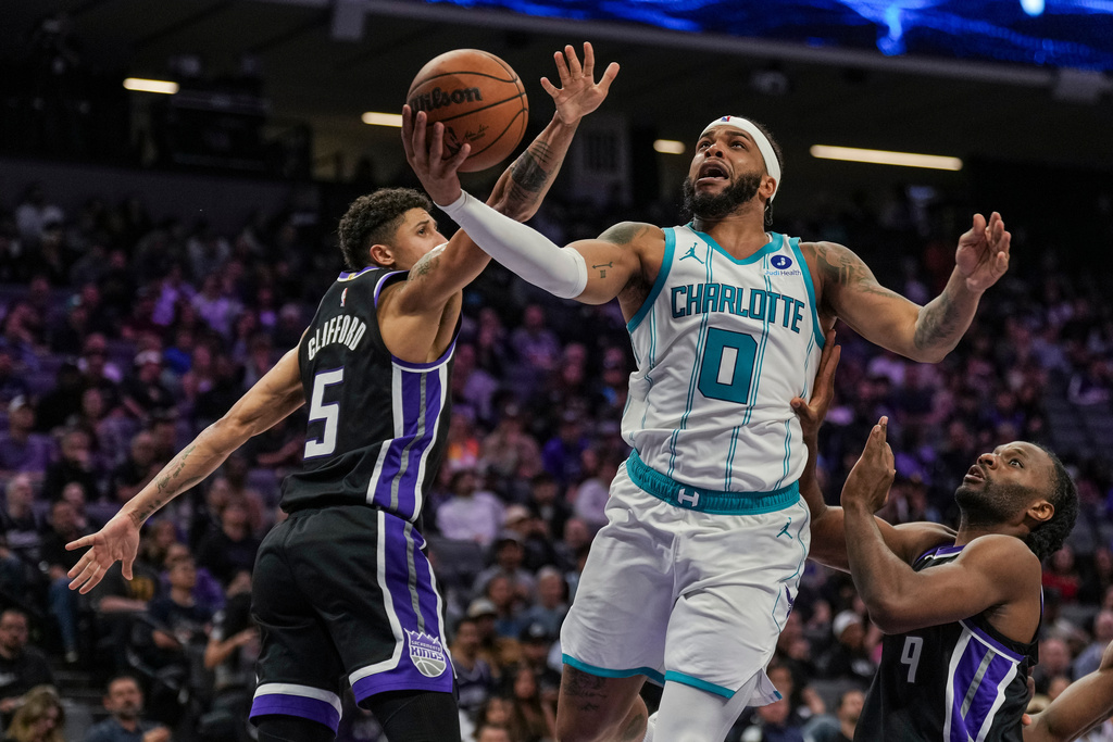 Charlotte Hornets forward Miles Bridges (0) goes for a layup against Sacramento Kings guard Nique Clifford (5) during the second half of an NBA basketball game, Wednesday, March 11, 2026, in Sacramento, Calif. (AP Photo/Justine Willard)