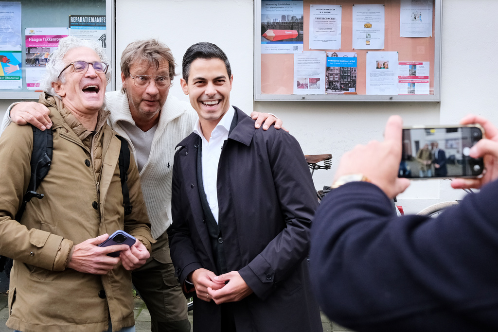 Rob Jetten, leader of the center-left D66 party, right, poses for a mobile phone photo as he leaves a polling station after casting his vote during general elections in The Hague, Netherlands, Wednesday, Oct. 29, 2025. (AP Photo/Patrick Post)