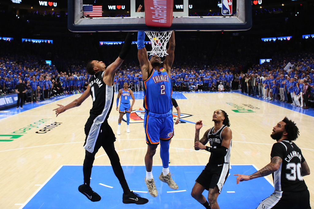 Oklahoma City Thunder guard Shai Gilgeous-Alexander (2) dunks against San Antonio Spurs forward Victor Wembanyama (1) during the first half of Game 1 in a third-round NBA basketball playoffs series Monday, May 18, 2026, in Oklahoma City. (AP Photo/Nate Billings)