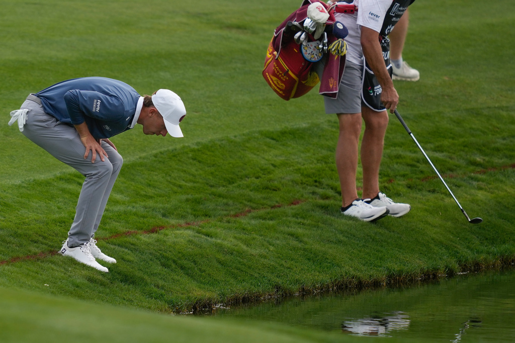 David Puig of Spain and his caddie look for the ball on 4th hole during the final round of the Dubai Desert Classic in United Arab Emirates, Sunday, Jan. 25, 2026. (AP Photo/Altaf Qadri)