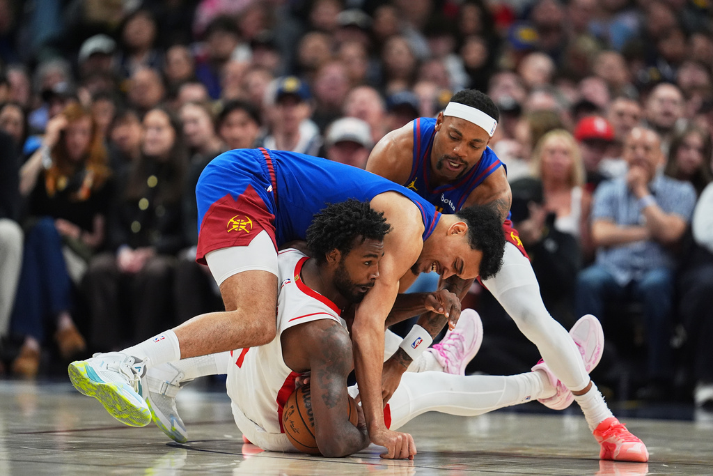 Houston Rockets forward Tari Eason, front bottom, fights for control of a loose ball with Denver Nuggets forward Spencer Jones, front top, and guard Bruce Brown in the first half of an NBA basketball game, Wednesday, March 11, 2026, in Denver. (AP Photo/David Zalubowski)