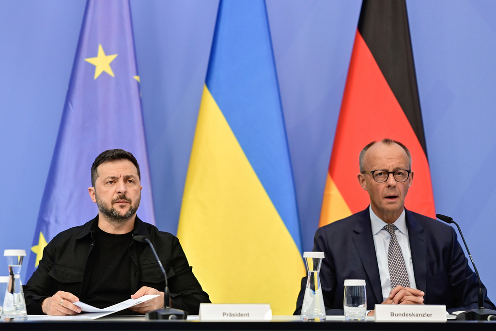 Ukrainian President Volodymyr Zelenskyy, left, and German Chancellor Friedrich Merz attend a video meeting of European leaders with US President Donald Trump on the Ukraine war in Berlin, Germany, Wednesday, Aug. 13, 2025, ahead of the summit between the US and Russian leaders. (John MacDougall/Pool Photo via AP)