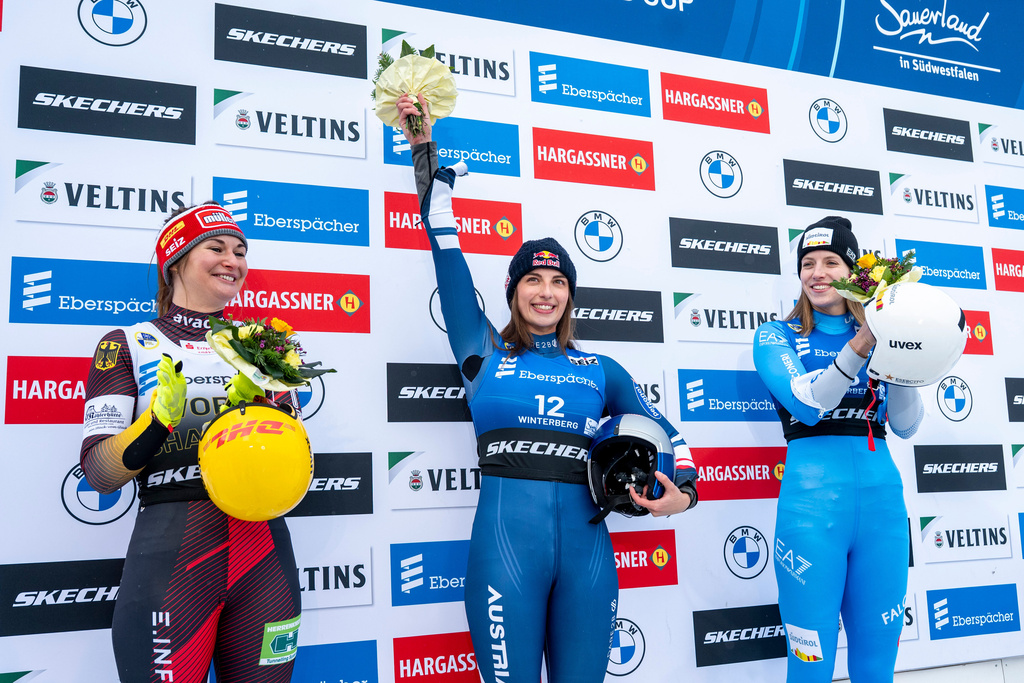 Runner-up Julia Taubitz, of Germany, from left, winner Hannah Prock, of Austria, and third-placed Verena Hofer, of Italy, celebrate on the podium following the Luge Women World Cup, single-seater, 2nd run in Winterberg, Germany, Saturday, Jan. 10, 2026. (David Inderlied/dpa via AP)