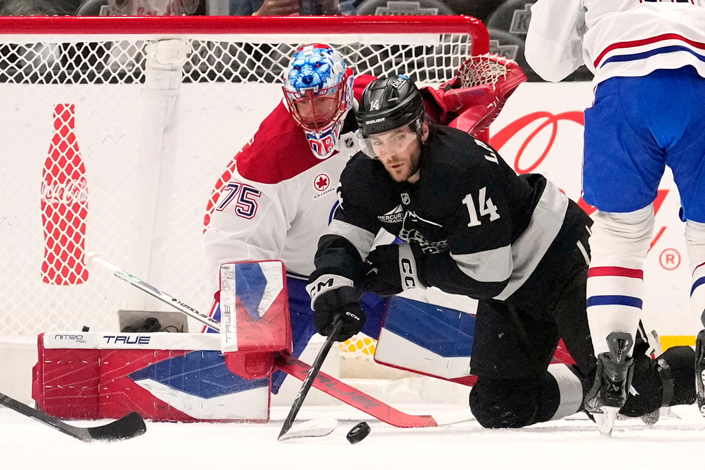 Los Angeles Kings right wing Alex Laferriere, right, passes the puck as Montréal Canadiens goaltender Jakub Dobes sits in goal during the first period of an NHL hockey game Saturday, March 7, 2026, in Los Angeles. (AP Photo/Mark J. Terrill)