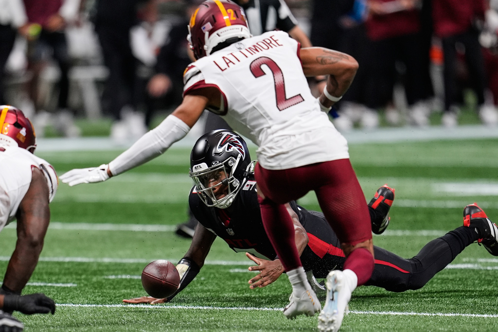 Atlanta Falcons quarterback Michael Penix Jr., below, recovers a fumble during the first half of an NFL football game against the Washington Commanders, Sunday, Sept. 28, 2025, in Atlanta. (AP Photo/Mike Stewart)