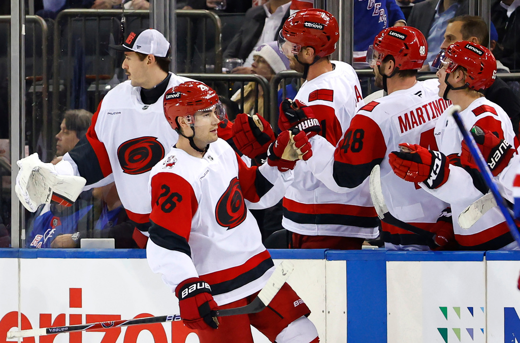 Carolina Hurricanes defenseman Sean Walker (26) celebrates with teammates after scoring a goal against the New York Rangers during the second period of an NHL hockey game, Tuesday Nov. 4, 2025, in New York. (AP Photo/Noah K. Murray)