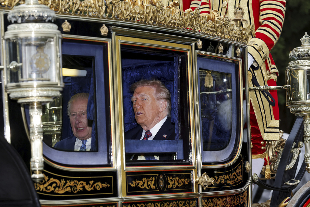 Britain's King Charles, left, and President Donald Trump sit in a carriage during a procession through Windsor Castle, England, Wednesday, Sept. 17, 2025. (Toby Melville/Pool Photo via AP)