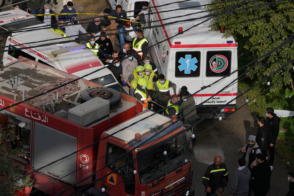 Rescue workers carry a body from an apartment destroyed in an Israeli airstrike in the southern port city of Sidon, Lebanon, Saturday, March 14, 2026. (AP Photo/Mohammad Zaatari)