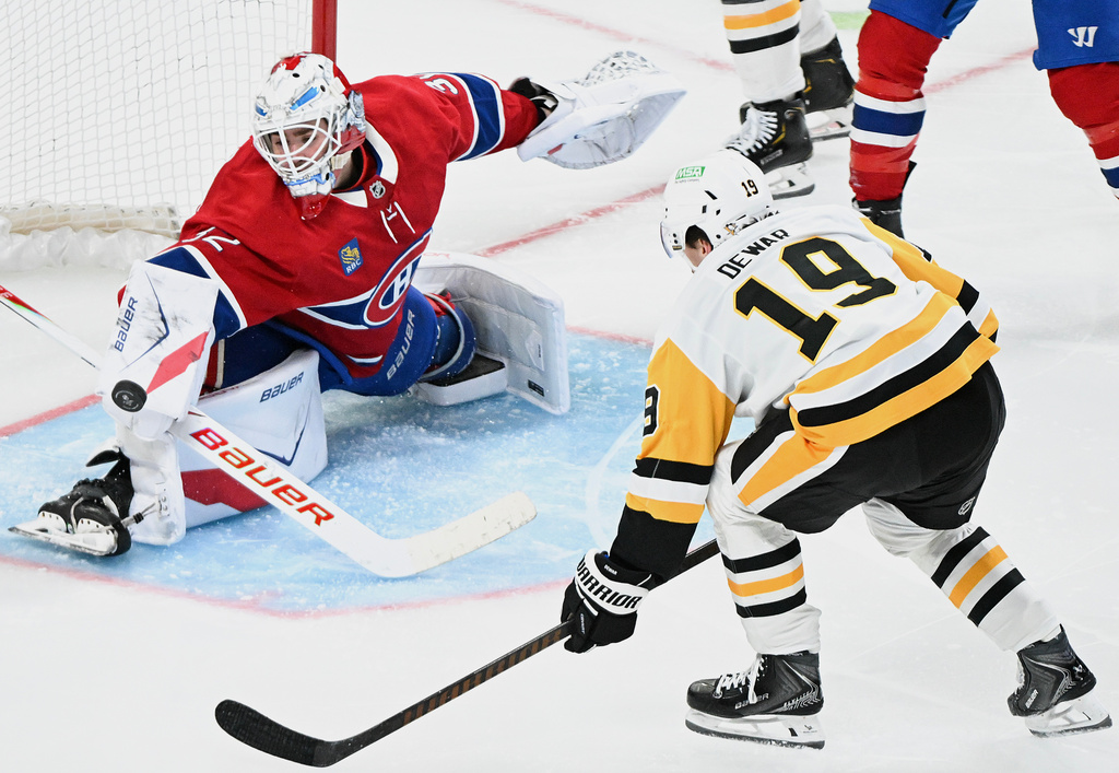 Montreal Canadiens goaltender Jacob Fowler (32) makes a save against Pittsburgh Penguins' Connor Dewar (19) during the second period of an NHL hockey game, in Montreal, Saturday, Dec. 20, 2025. (Graham Hughes/The Canadian Press via AP)