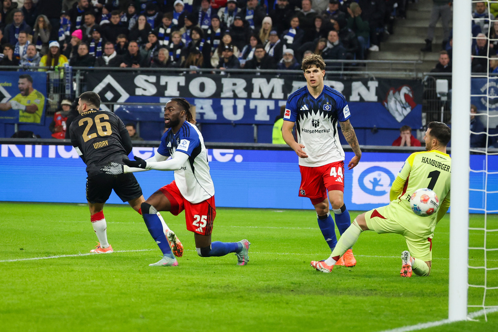 Stuttgart's Deniz Undav, left, scores their side's first goal of the game against Hamburger's Mario Vuskovic, Jordan Torunarigha and goalkeeper Daniel Heuer Fernandes during the German Bundesliga soccer match between Hamburger SV and VfB Stuttgart in Hamburg, Germany, Sunday, Nov. 30, 2025. (Christian Charisius/dpa via AP)